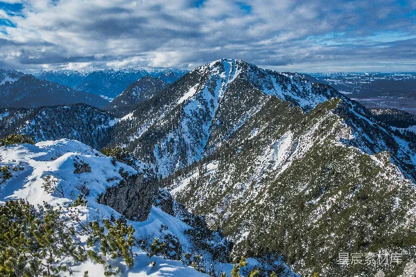高清摄影 白天多云的天空下覆盖着积雪的山峰