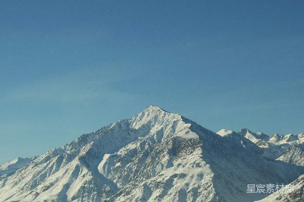 高清摄影 雪山在明亮的蓝天背景下矗立。