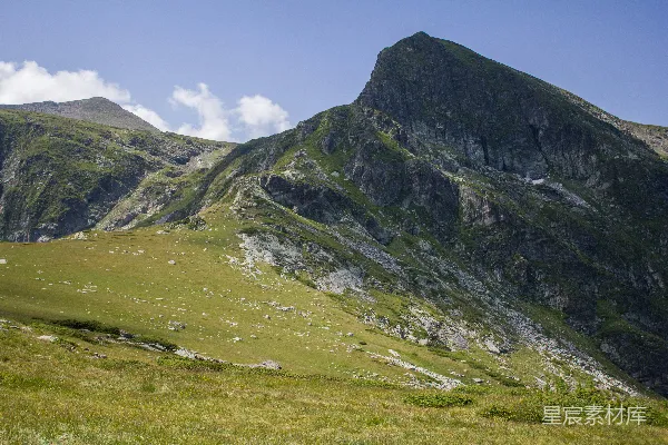 高清摄影 一片草地，背景有一座山。