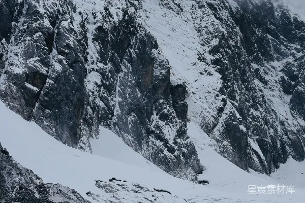 高清摄影 一座被雪覆盖的山，周围被云雾环绕。