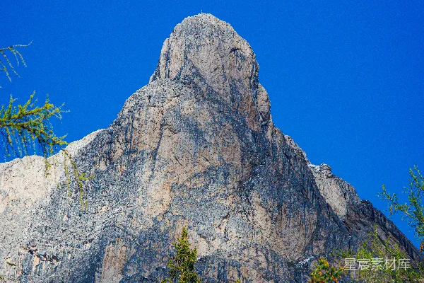 高清摄影 巍峨的落基山脉峰峦在活力四射的蓝天映衬下，树木环绕。
