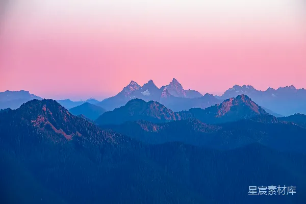 高清摄影 日出时分，层峦叠嶂的山峦，天空呈现出粉红色。