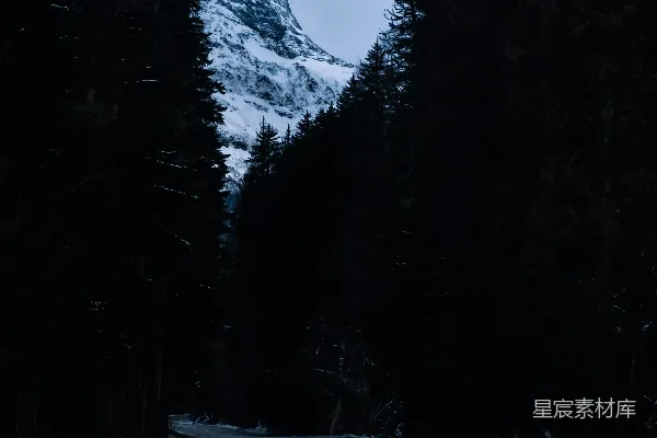 高清摄影 一条路，背景是被雪覆盖的山峰。