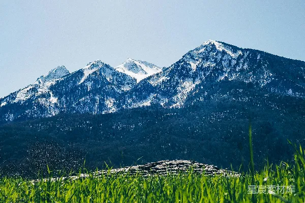 高清摄影 一片草地上有山脉作为背景。