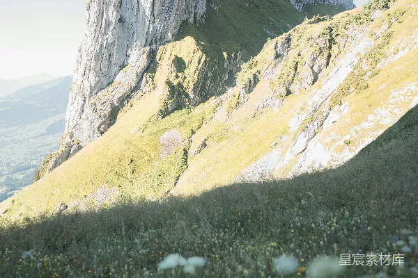 高清摄影 崎岖的山峰矗立在草坡之上。