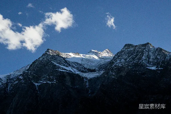 高清摄影 覆盖着雪的山峰，天空中有一朵云。