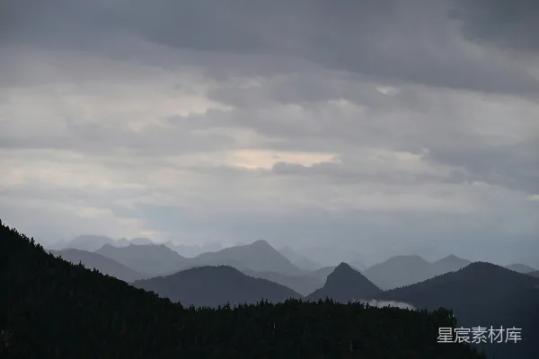 高清摄影 连绵的山脉在多云、大气的天空下。