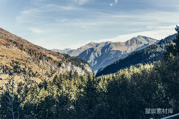 高清摄影 一片山脉的风景，前景中有树木。