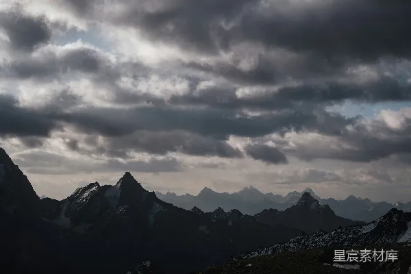 高清摄影 一个人站在山顶，天空中云层密布。