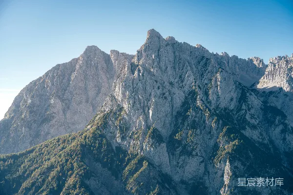 高清摄影 在晴朗的蓝天之下，山峰尖锐嶙峋。