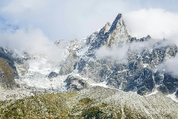 高清摄影 被雪覆盖的山峰，天空中有云。