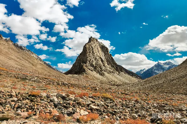 高清摄影 一座雄伟的岩石山峰在广阔的荒漠景观中占据主导地位。