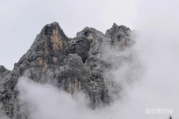 高清摄影 灰白色的岩石山峰上覆盖着白云。
