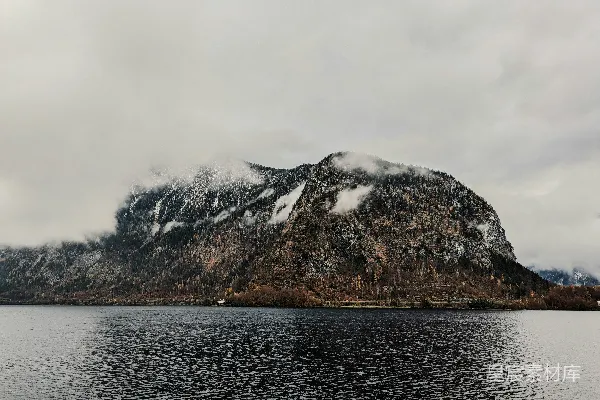 高清摄影 一片覆盖着积雪的山峰紧邻一片水域。