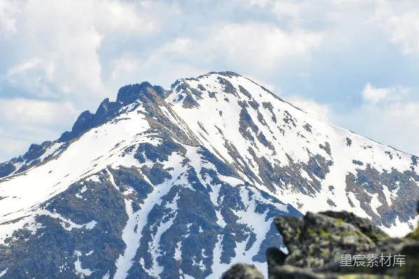高清摄影 白雪皑皑的山峰在云层之下，绿意盎然的前景之上高耸。