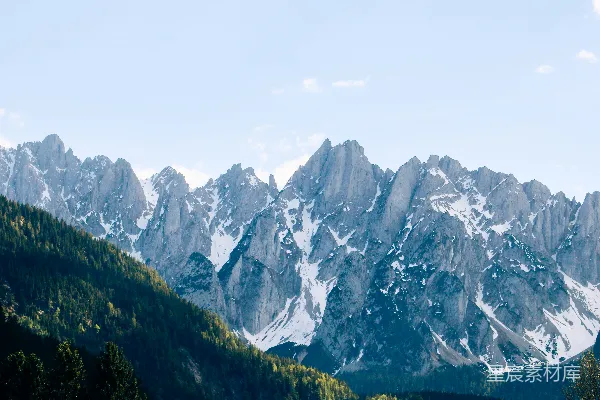 高清摄影 巍峨的雪山拔地而起，矗立于郁郁葱葱的森林之上。