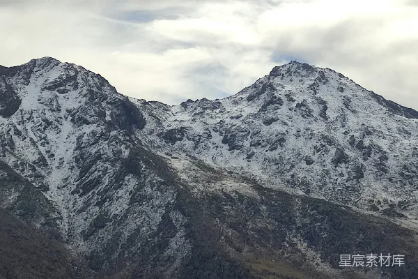 高清摄影 连绵的雪山在阴云密布的天空下。