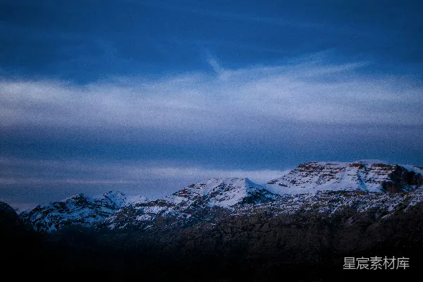 高清摄影 雪山覆盖的山脉在多云的蓝天之下