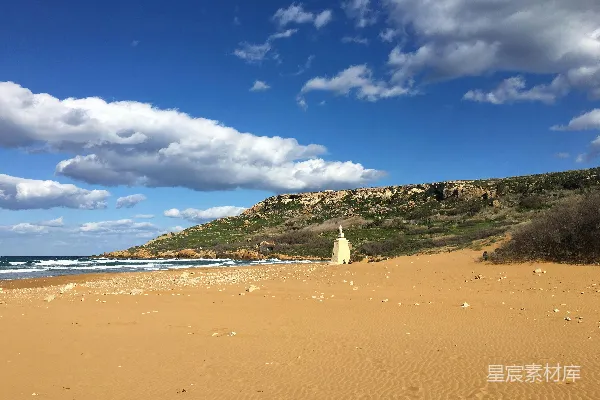 高清摄影 一个沙滩，背景中有一座小山。