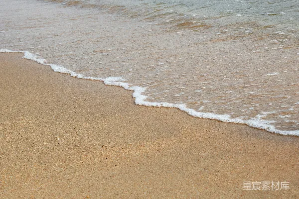 高清摄影 一个沙滩上有海浪拍打岸边。