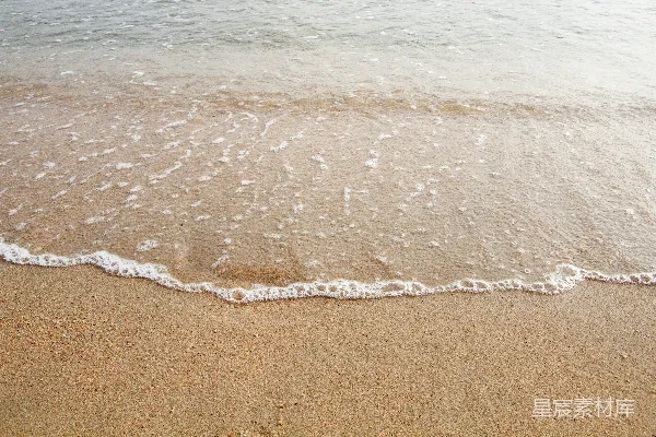 高清摄影 一个沙滩，海浪拍打着岸边。