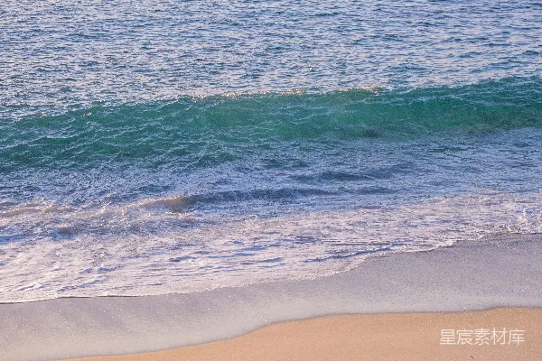高清摄影 一个男人在覆盖着海浪的海滩上骑着冲浪板。