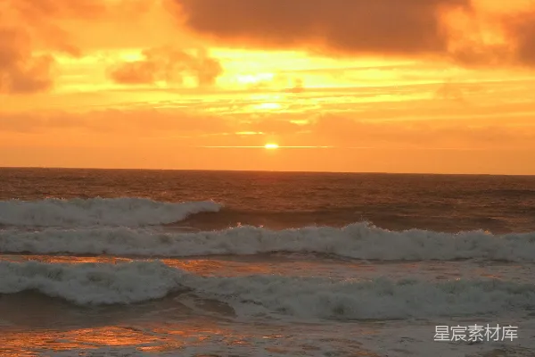 高清摄影 夕阳正照耀在海洋上，海浪轻轻拍打着岸边。