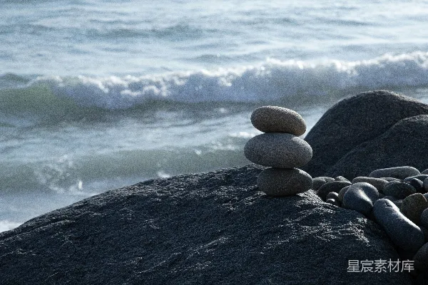 高清摄影 一堆岩石坐落在海滩上，靠近大海。