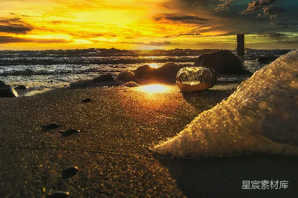 高清摄影 日落时分，海滩上散布着岩石。