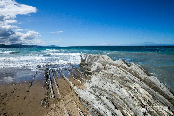 高清摄影 一个沙滩，海浪正朝着岸边涌来。