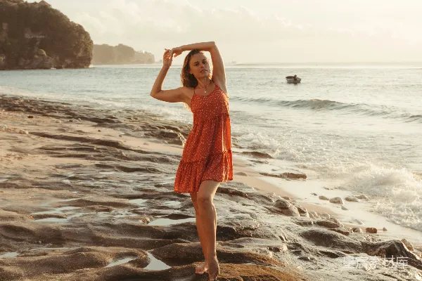 高清摄影 一个女人站在海滩上，旁边是海洋。
