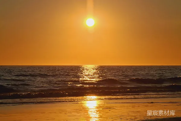 高清摄影 夕阳正悬挂在海面上，在海滩上落下。