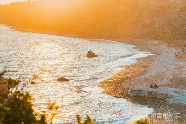 高清摄影 夕阳正照耀在海滩上，海面波光粼粼。