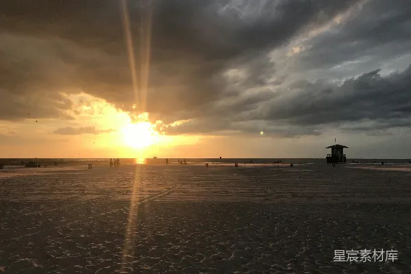高清摄影 夕阳西下，海滩上有人影。