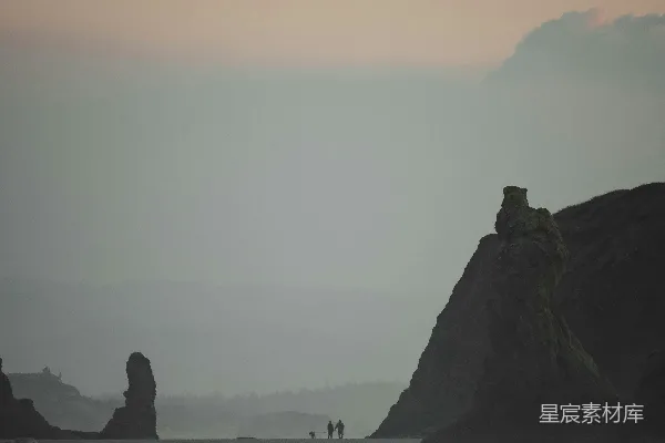 高清摄影 一个沙滩，沙滩上有一群大岩石漂浮在水中。