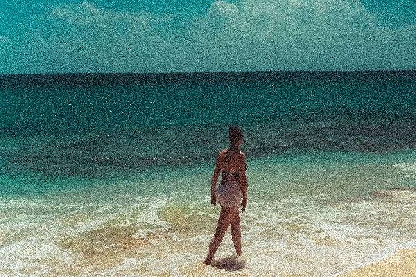 高清摄影 一个穿着比基尼的女人站在海滩上。
