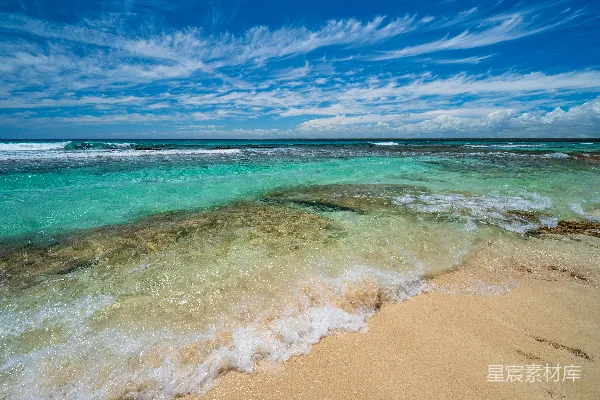 高清摄影 沙滩细腻，清澈的蓝水在部分多云的天空下。