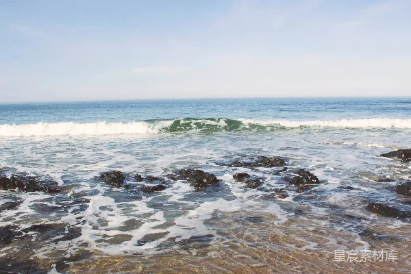 高清摄影 一个海滩，海浪正冲向岸边。