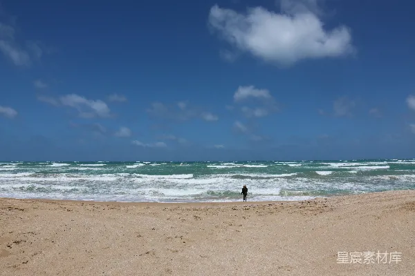 高清摄影 站在海滩上，靠近海洋旁边的人