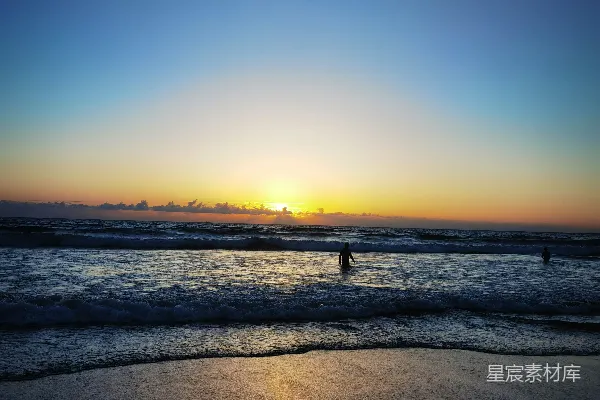 高清摄影 夕阳正映照在海洋上，海滩上一片霞光。
