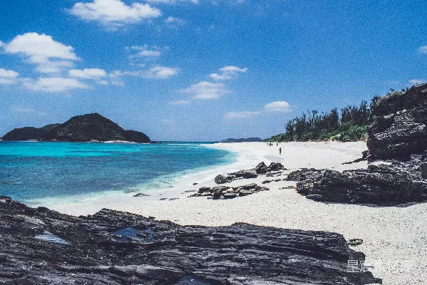 高清摄影 人们在靠近山边的海边散步。