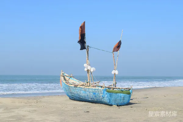 高清摄影 蓝天晴空下的海滩岸边有一艘蓝色的船。
