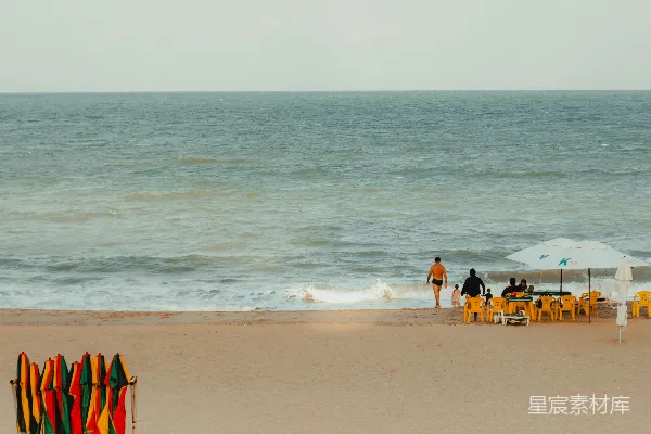 高清摄影 色彩斑斓的冲浪板在沙滩上，海浪拍打着岸边。