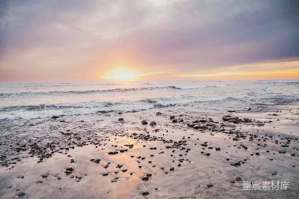 高清摄影 夕阳正照耀着海滩上的海洋。