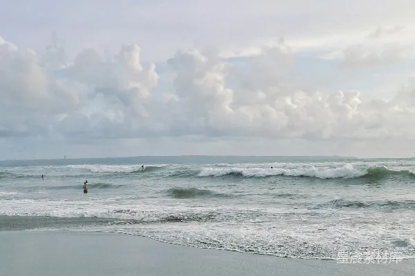 高清摄影 一群人在海滩上，靠近大海站着。