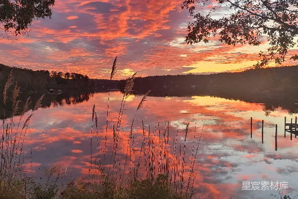 高清摄影 湖边有一艘船停在码头上，夕阳洒在湖面上，景色非常美丽。