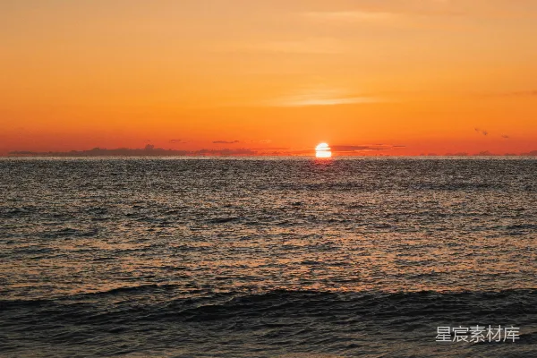 高清摄影 夕阳映照着大海，远处有一艘船。