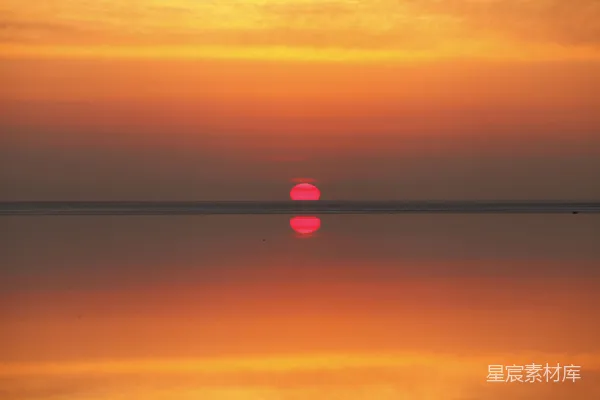 高清摄影 一片广阔的水域，背景中是夕阳。