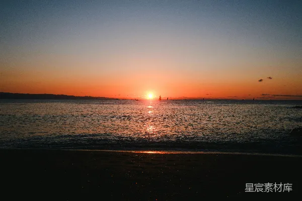 高清摄影 夕阳正缓缓地沉落在海滩的海面上。