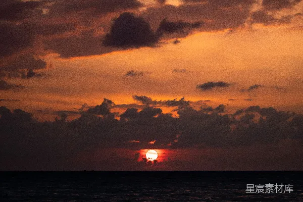 高清摄影 在多云的天气里，太阳正在海面上落下。